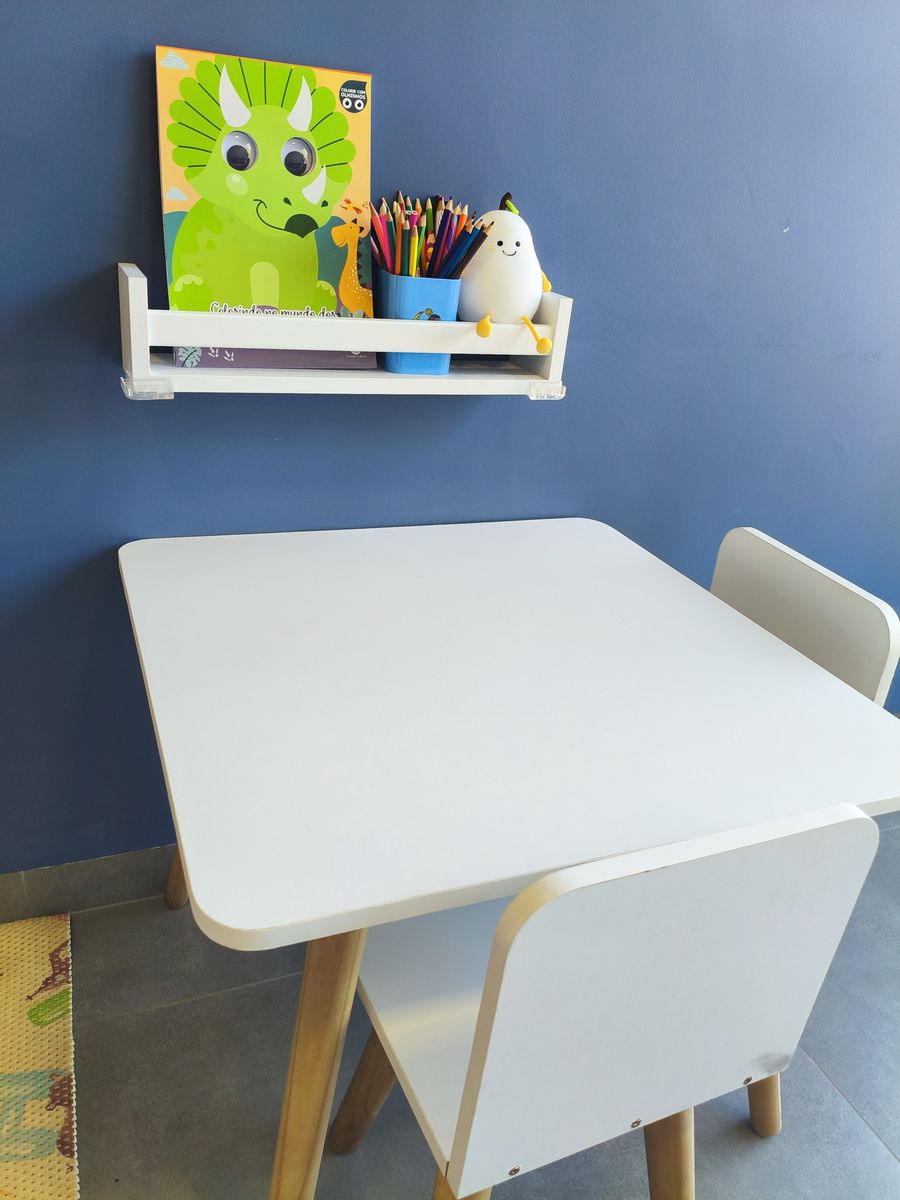 Mesa e cadeiras no tamanho das crianças, com livro de colorir e lápis